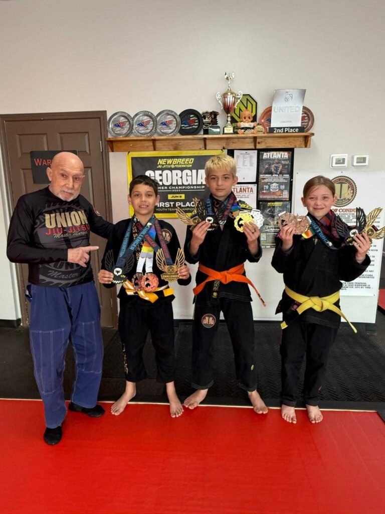 Grandmaster Ricardo Murgel with three Union Team BJJ youth competitors displaying medals